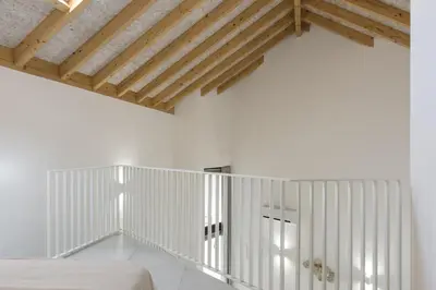 a bedroom with white walls and wooden ceilings at Madalena Village 3 - City centre by HD PROPERTIES in Faro