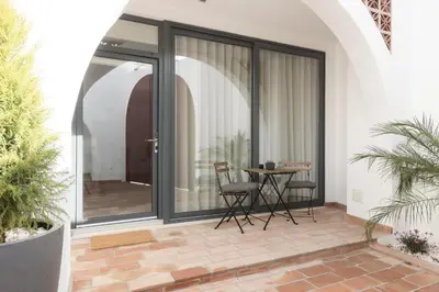 a patio with sliding glass doors with a table and chairs at Madalena Village 4 - City centre by HD PROPERTIES in Faro