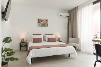 a white bedroom with a large bed and a window at Madalena Village 5 - City centre by HD PROPERTIES in Faro