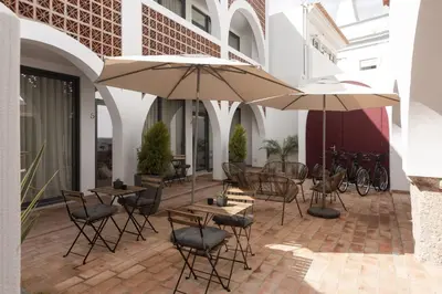 a patio with tables and chairs and umbrellas at Madalena Village 5 - City centre by HD PROPERTIES in Faro