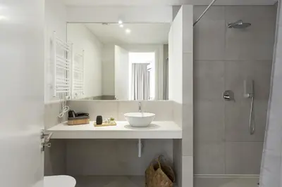 a bathroom with a sink and a shower with a mirror at Madalena Village 6 - City centre by HD PROPERTIES in Faro