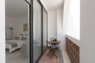 a bedroom with a bed and a table and a mirror at Madalena Village 6 - City centre by HD PROPERTIES in Faro