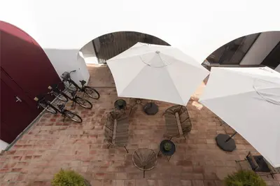 two white umbrellas and chairs on a brick patio at Madalena Village 7 - City centre by HD PROPERTIES in Faro