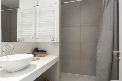 a bathroom with a white sink and a shower at Madalena Village 7 - City centre by HD PROPERTIES in Faro