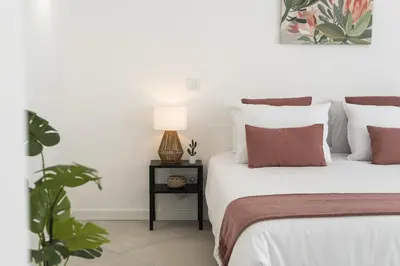 a bedroom with two beds and a table with a lamp at Madalena Village 7 - City centre by HD PROPERTIES in Faro