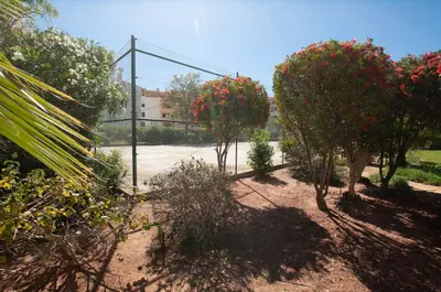 a group of trees and bushes next to a fence at Ondas Verdes by OCvillas in Albufeira
