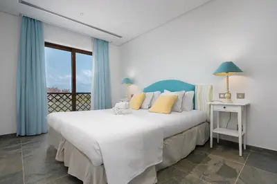 a bedroom with a large white bed and a window at Elegance Apartment W/ Balcony & Pool by LovelyStay in Albufeira