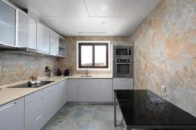 a kitchen with white cabinets and a black counter top at Elegance Apartment W/ Balcony & Pool by LovelyStay in Albufeira