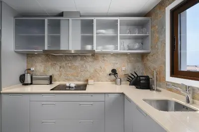 a kitchen with white cabinets and a sink and a window at Elegance Apartment W/ Balcony & Pool by LovelyStay in Albufeira