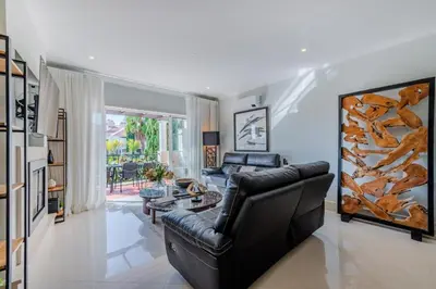 a living room with a black leather couch and a table at 5 star Luxury Palmview apartment with large terrace and communal pool in Quarteira