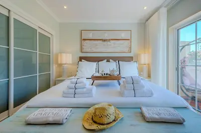 a bedroom with a large white bed with towels on it at 5 star Luxury Palmview apartment with large terrace and communal pool in Quarteira