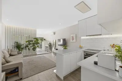 a kitchen with white cabinets and a living room at Silver Lux Studio 2 - City Center by HD PROPERTIES in Vilamoura