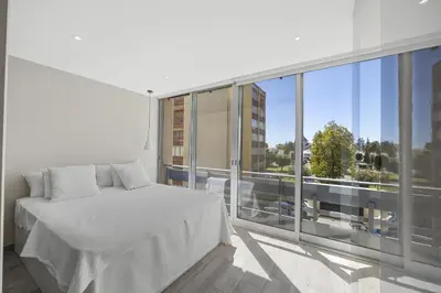 a white bedroom with a bed and a large window at Silver Lux Studio 1 - City Center by HD PROPERTIES in Vilamoura