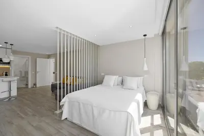 a white bedroom with a white bed and a kitchen at Silver Lux Studio 1 - City Center by HD PROPERTIES in Vilamoura