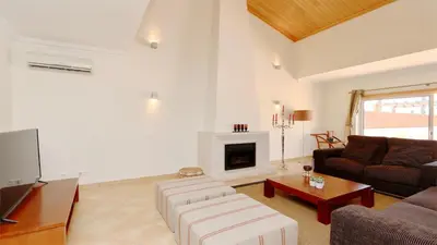 a living room with a couch and a fireplace at Villa Nuki- CleverDetails, quiet location, sleeps 8, private pool in Vilamoura