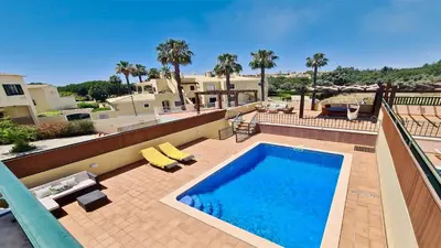 a swimming pool on a patio with palm trees at Villa Nuki- CleverDetails, quiet location, sleeps 8, private pool in Vilamoura