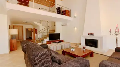 a living room with two couches and a fireplace at Villa Nuki- CleverDetails, quiet location, sleeps 8, private pool in Vilamoura