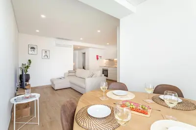 a dining room and living room with a table and chairs at Centralgarve - Premium Apartment in the Center of Vilamoura - Cota10 in Vilamoura
