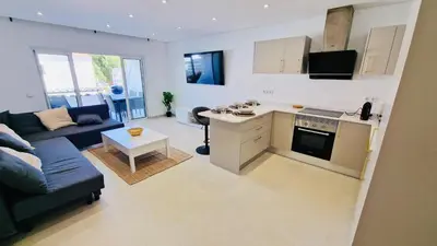 a kitchen and living room with a couch and a table at Your dream Getaway Awaits in Vale do Lobo in Almancil