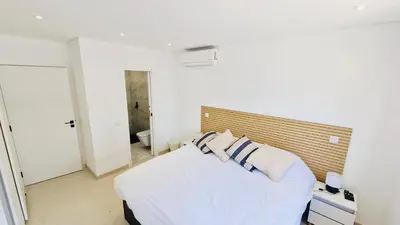 a bedroom with a white bed with blue and white pillows at Your dream Getaway Awaits in Vale do Lobo in Almancil