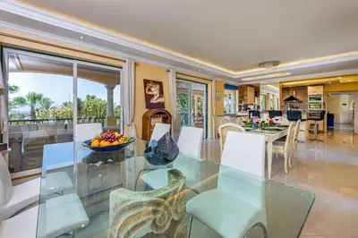 a dining room and living room with a glass table and chairs at Villa Casa do Monte in Albufeira