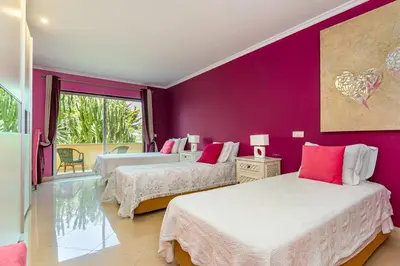 a bedroom with two beds and a purple wall at Villa Casa do Monte in Albufeira
