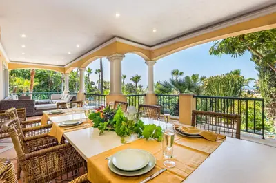 a dining room with tables and chairs and a balcony at Villa Casa do Monte in Albufeira