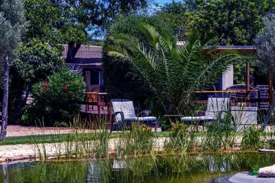 a couple of chairs sitting next to a body of water at Villa Algarve 4 Ensuite Bedrooms, Private Swimming Pool, Beautiful Gardens with water features and natural Bio Pool in Almancil