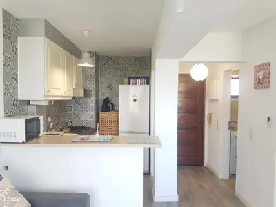 a kitchen with white cabinets and a white refrigerator at Studio Praia de Quarteira in Quarteira