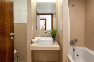 a bathroom with a sink and a tub and a mirror at TAC - Salgados Beach Prime Pool Resort in Guia