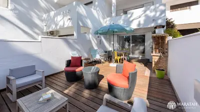 a patio with chairs and tables and an umbrella at Townhouse Farah in Vale do Lobo