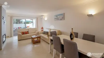 a living room with a couch and a dining room table at Townhouse Farah in Vale do Lobo