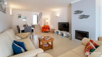 a living room with a couch and a fireplace at Townhouse Farah in Vale do Lobo