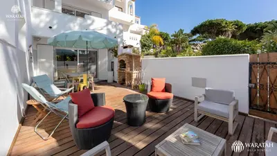 a patio with chairs and an umbrella on a deck at Townhouse Farah in Vale do Lobo