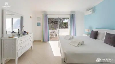 a white bedroom with a large bed and a dresser at Townhouse Farah in Vale do Lobo