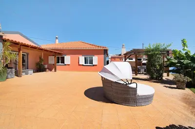 a wicker chair sitting on a patio in front of a house at At-tunis in Tunes