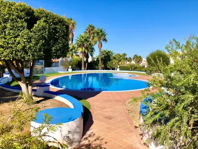 a large swimming pool in a yard with trees at Jardins da Galé Beach House in Albufeira
