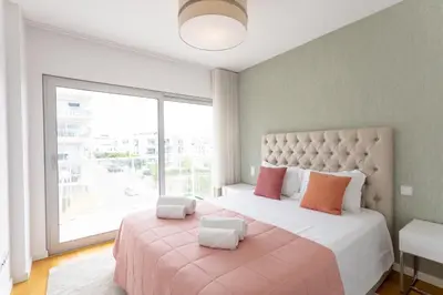 a bedroom with a large bed with a large window at Glamour Apartment With Pool in Albufeira