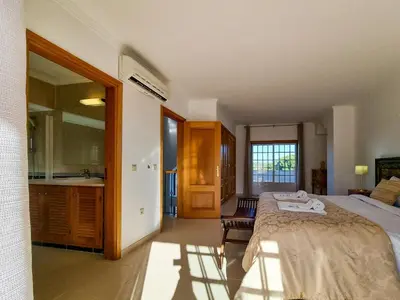 a bedroom with a large bed and a bathroom at FLH Quinta das Salinas Triplex with Balcony in Vale do Lobo