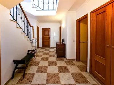 a hallway with a checkered floor and a bench at FLH Quinta das Salinas Triplex with Balcony in Vale do Lobo