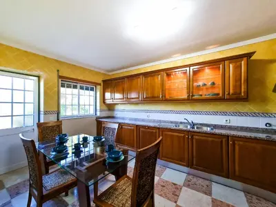 a kitchen with a table and chairs and a sink at FLH Quinta das Salinas Triplex with Balcony in Vale do Lobo