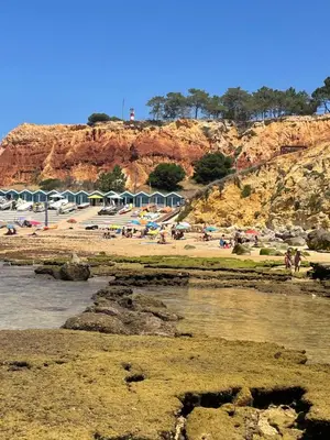 a group of people on a beach near a mountain at Varanda para o Mar in Albufeira