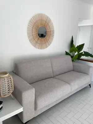 a gray couch in a living room with a mirror at Varanda para o Mar in Albufeira
