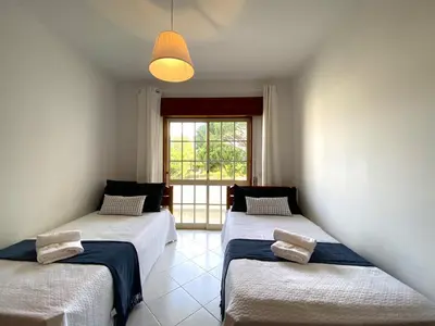 three beds in a room with a window at Vilamoura Garden View 2 With Pool by Homing in Vilamoura