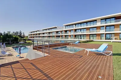 a large building with a deck with a swimming pool at White & Nature Apartment in Vilamoura