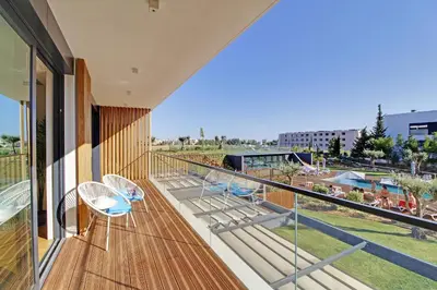 a balcony with chairs and a view of a park at White & Nature Apartment in Vilamoura