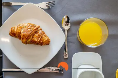 a table with a plate of food and a glass of orange juice at #160 V3 Vila Branca 92 by Home Holidays in Albufeira