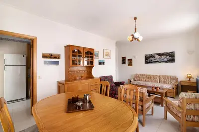 a kitchen and living room with a table and chairs at Apartamento T1 Edisol in Quarteira