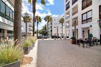 a courtyard with tables and chairs in a building at Apartamento T1 Edisol in Quarteira