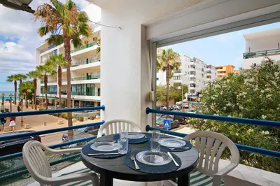 a table and chairs on a balcony with a view of the beach at Apartamento T1 Edisol in Quarteira